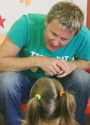 Picture of a childcare worker listening. They are facing us with their head slightly tilted.